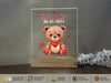 a clear acrylic with a teddy bear holding a heart