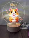 a glass ornament with a picture of a hamster on it