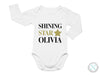 a white bodysuit with the words shining star ollivia on it