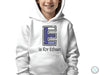 a young boy wearing a white hoodie with the letter e on it