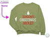 a green sweatshirt that says season&#39;s greetings violett