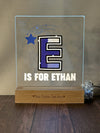 a glass plaque with the letter e is for ethan